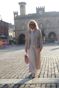 Professionista che cammina nel centro storico di Fidenza con luce naturale, davanti a un edificio storico – Patrizia Marzola psicologa online e Fidenza